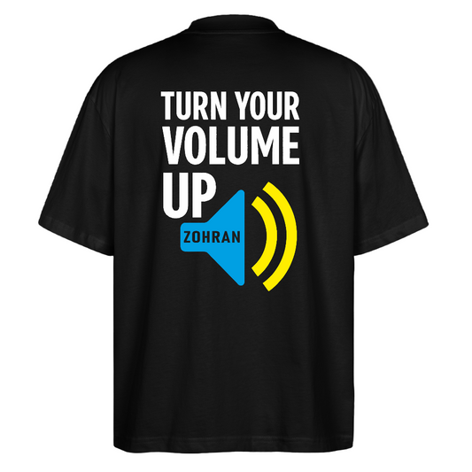 Back print close-up: "Back view large TURN YOUR VOLUME UP graphic with blue ZDRAM speech bubble and yellow sound-wave accents on black tee"
