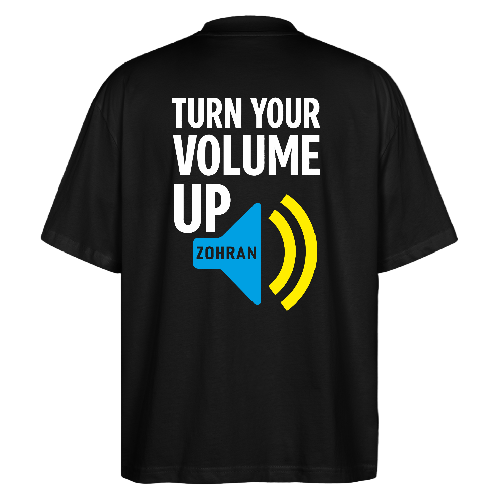 Back print close-up: "Back view large TURN YOUR VOLUME UP graphic with blue ZDRAM speech bubble and yellow sound-wave accents on black tee"