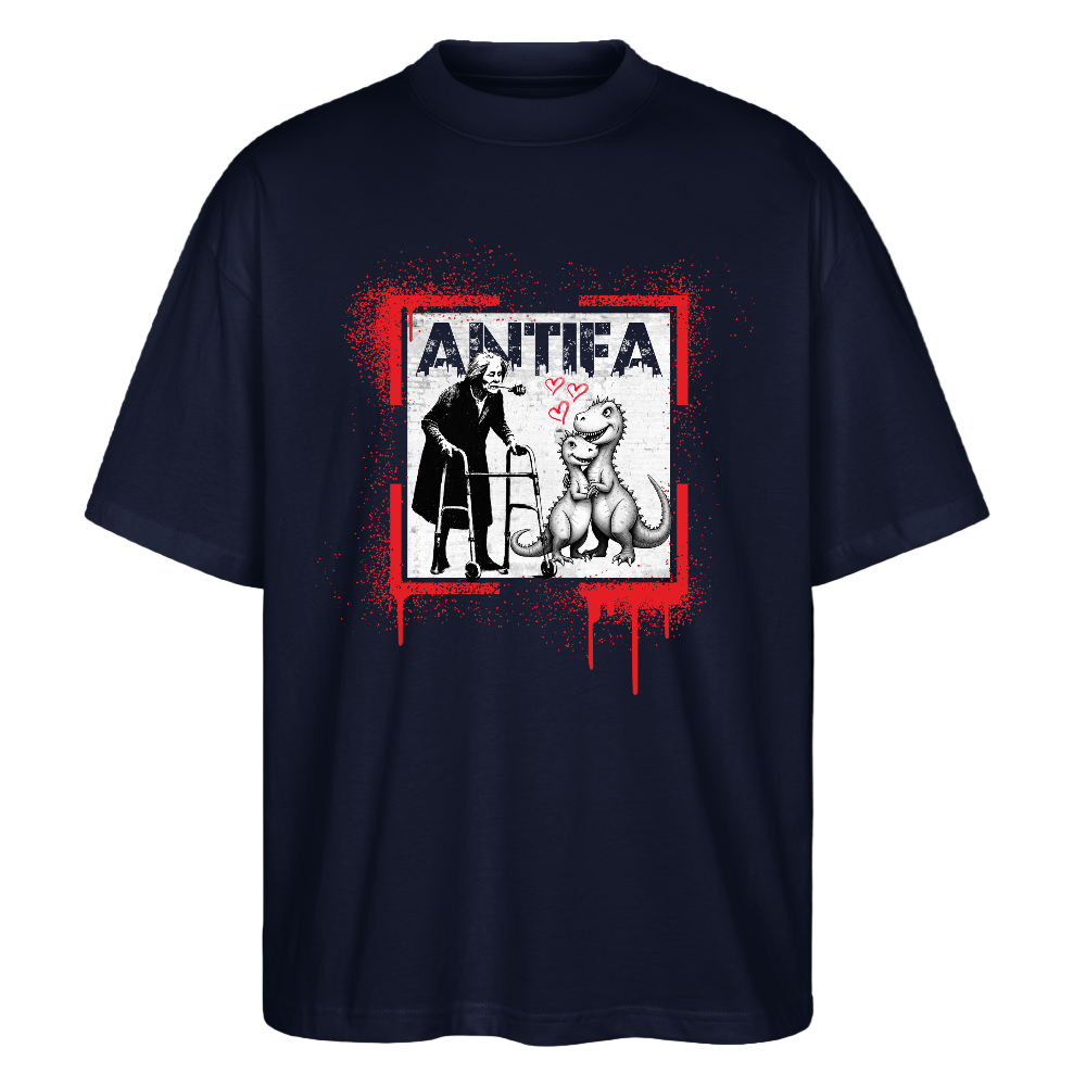 Navy unisex T‑shirt front graphic: red paint‑splatter square with dripping paint framing a person using a walker facing a seated dinosaur; pink hearts float between them and distressed white “ANTIFA” lettering appears above; organic cotton, screen‑printed protest artwork mixing street‑art aesthetics with an affectionate motif.