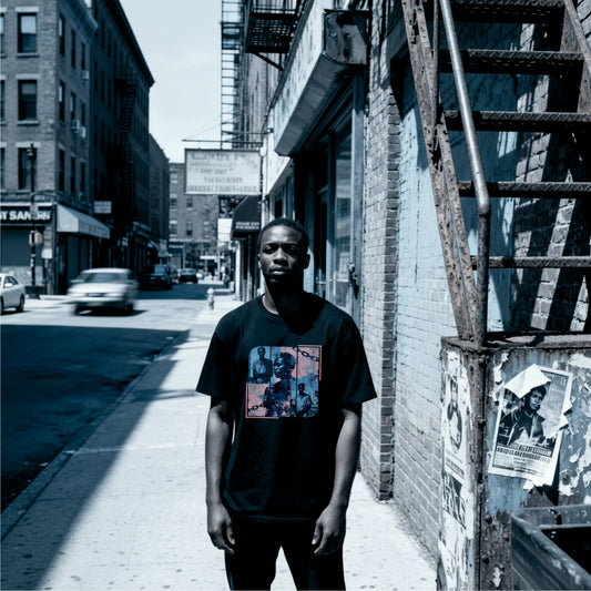 Schwarzes Oversize‑T‑Shirt mit blau‑rosa Portrait‑Collage auf der Vorderseite und großem „WHY?“ auf dem Rücken; Thema: Sklaverei‑Edition.